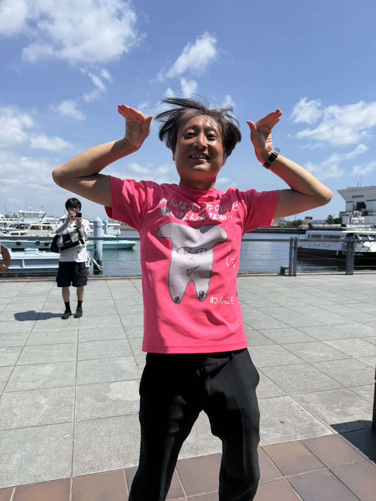 屋外でピンクのふにゅドライTシャツを着ている写真